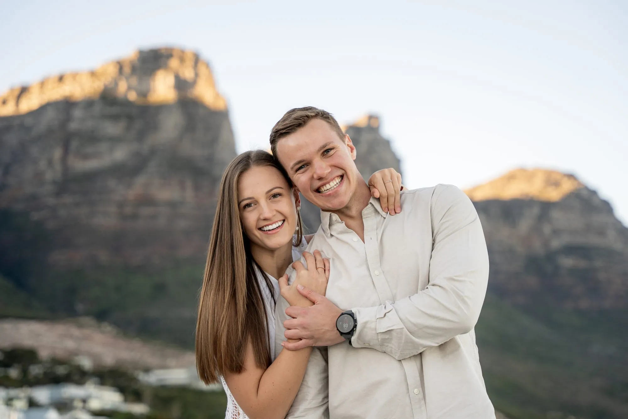 An engaged couple walking together at golden hour