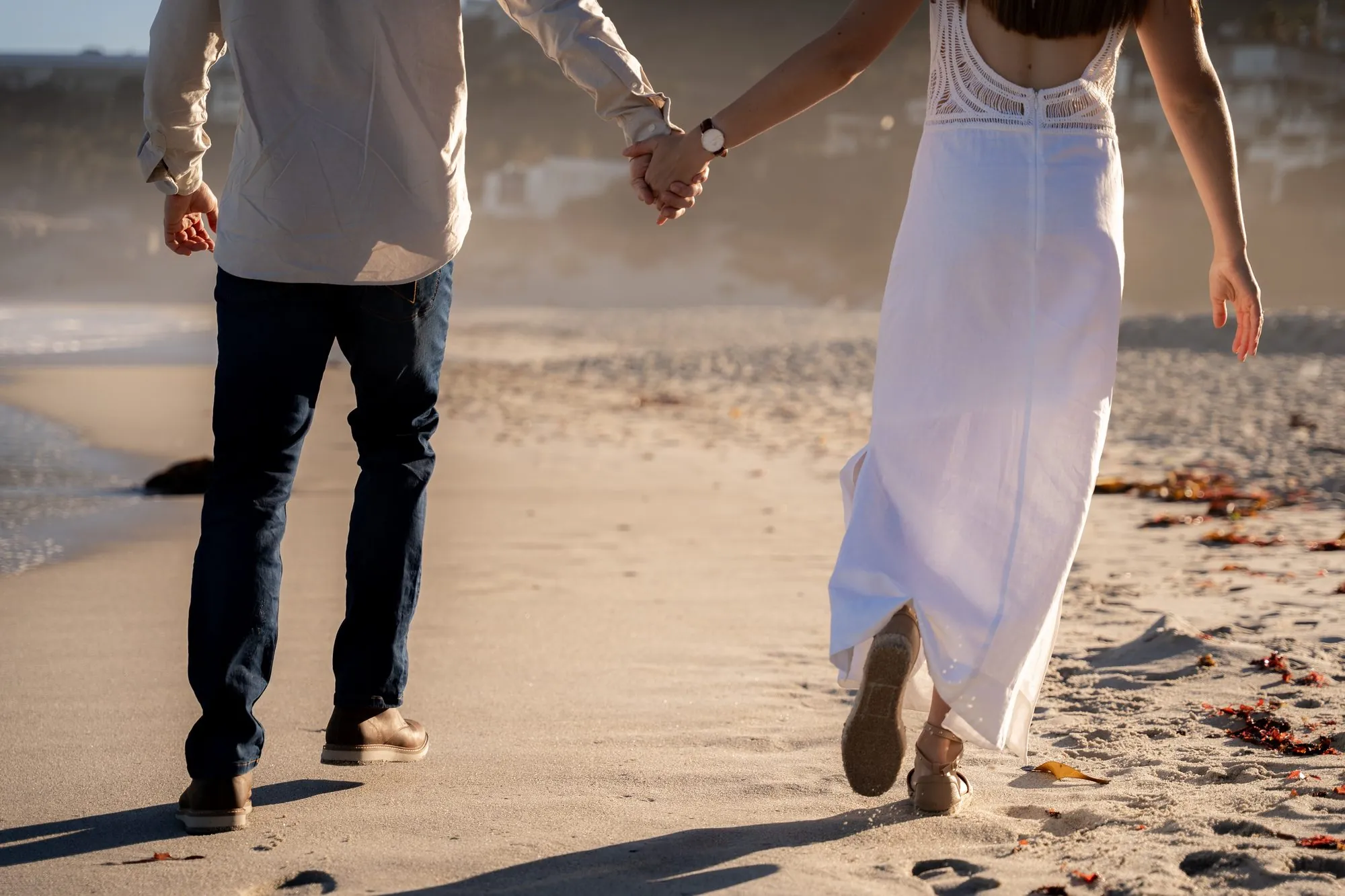 Couple walking hand in hand on a Cape Town beach