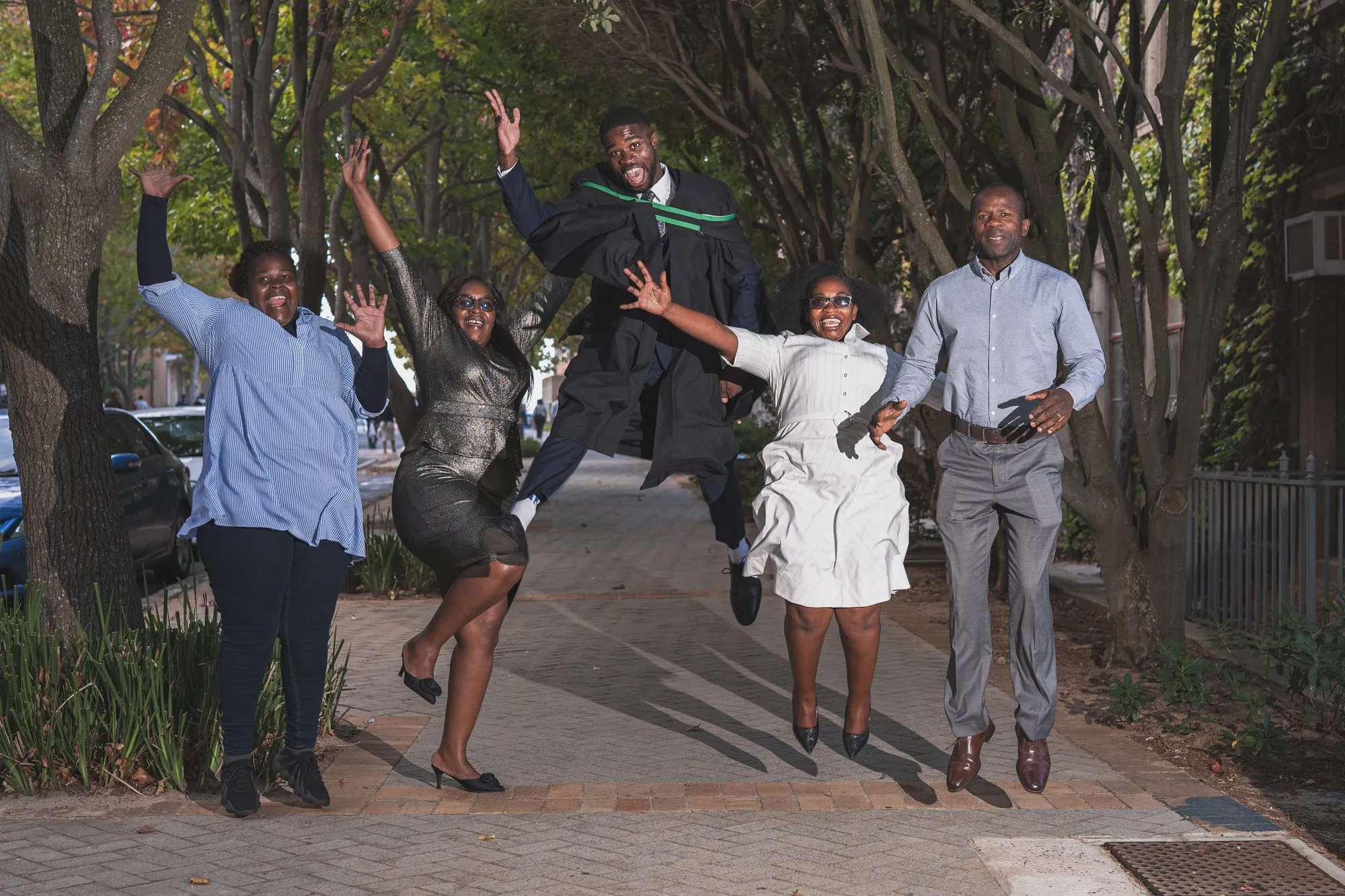 A graduate and family jumping for joy at UCT