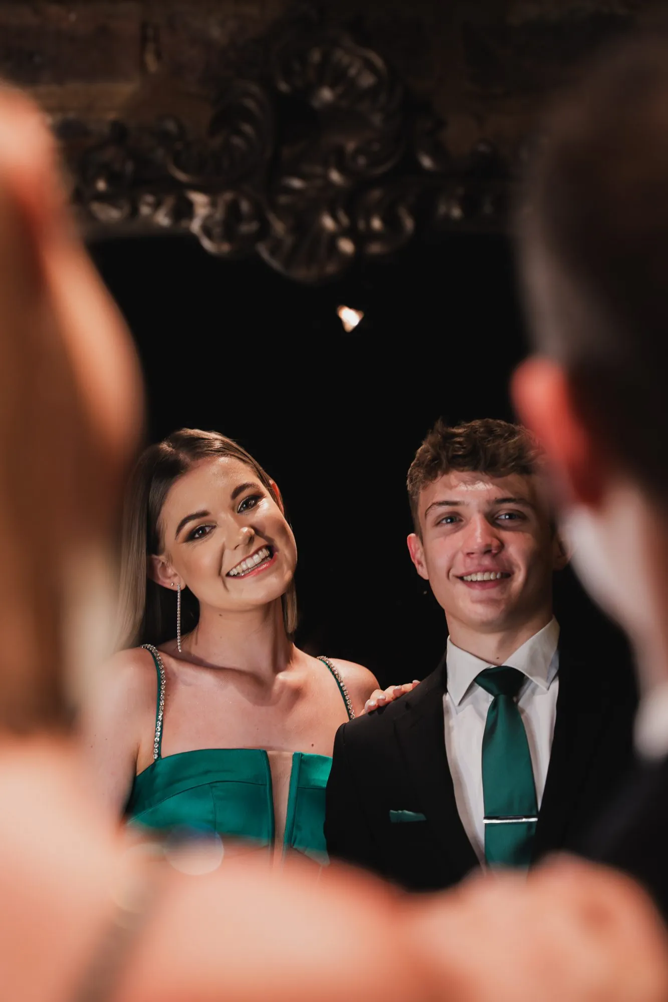 Matric dance couple smiling in an antique mirror