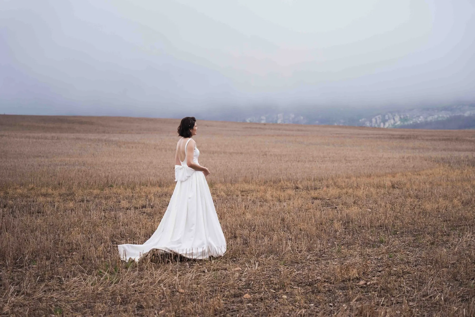A bride walking through a misty open field