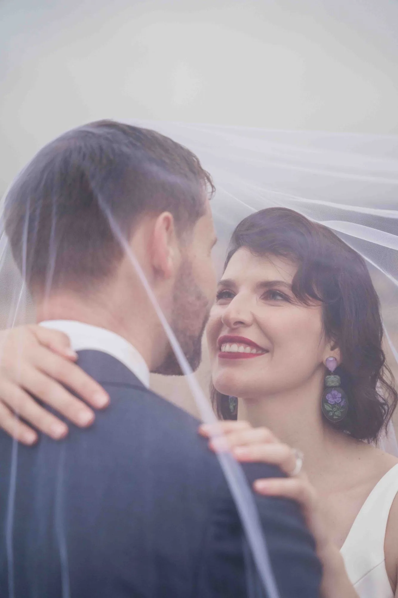 A couple beneath the bridal veil